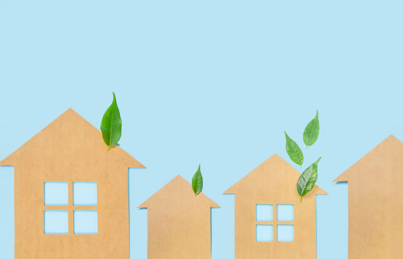 Illustration de maisons en carton avec des feuilles vertes sur un fond bleu clair, symbolisant la durabilité, l'écologie et les communautés énergétiques locales.